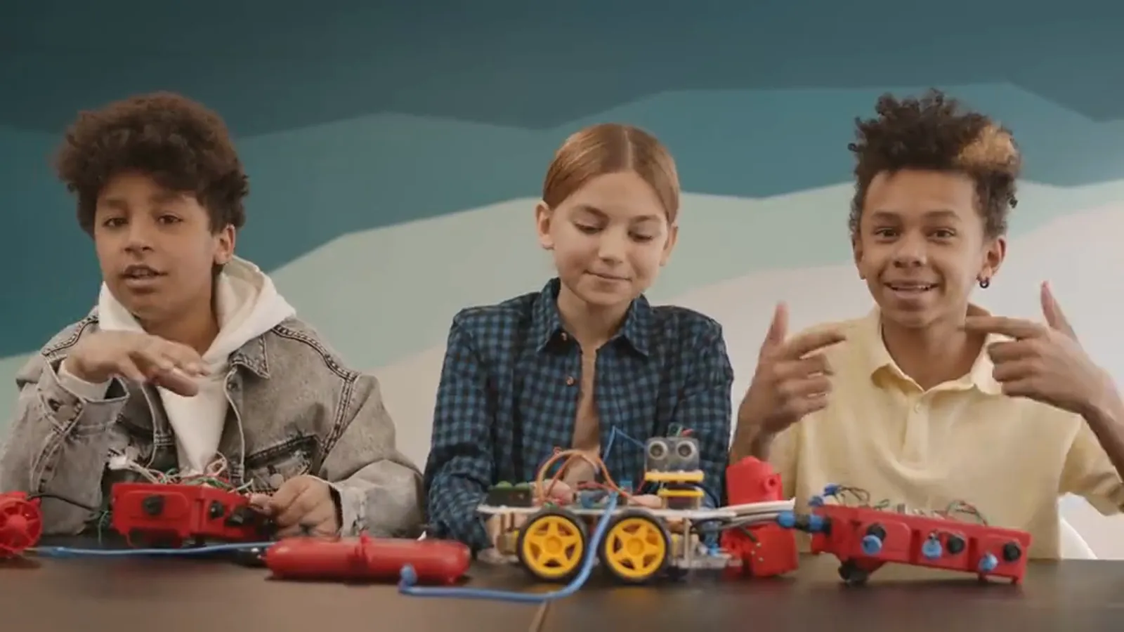 Young robotics teammates presenting their robot builds