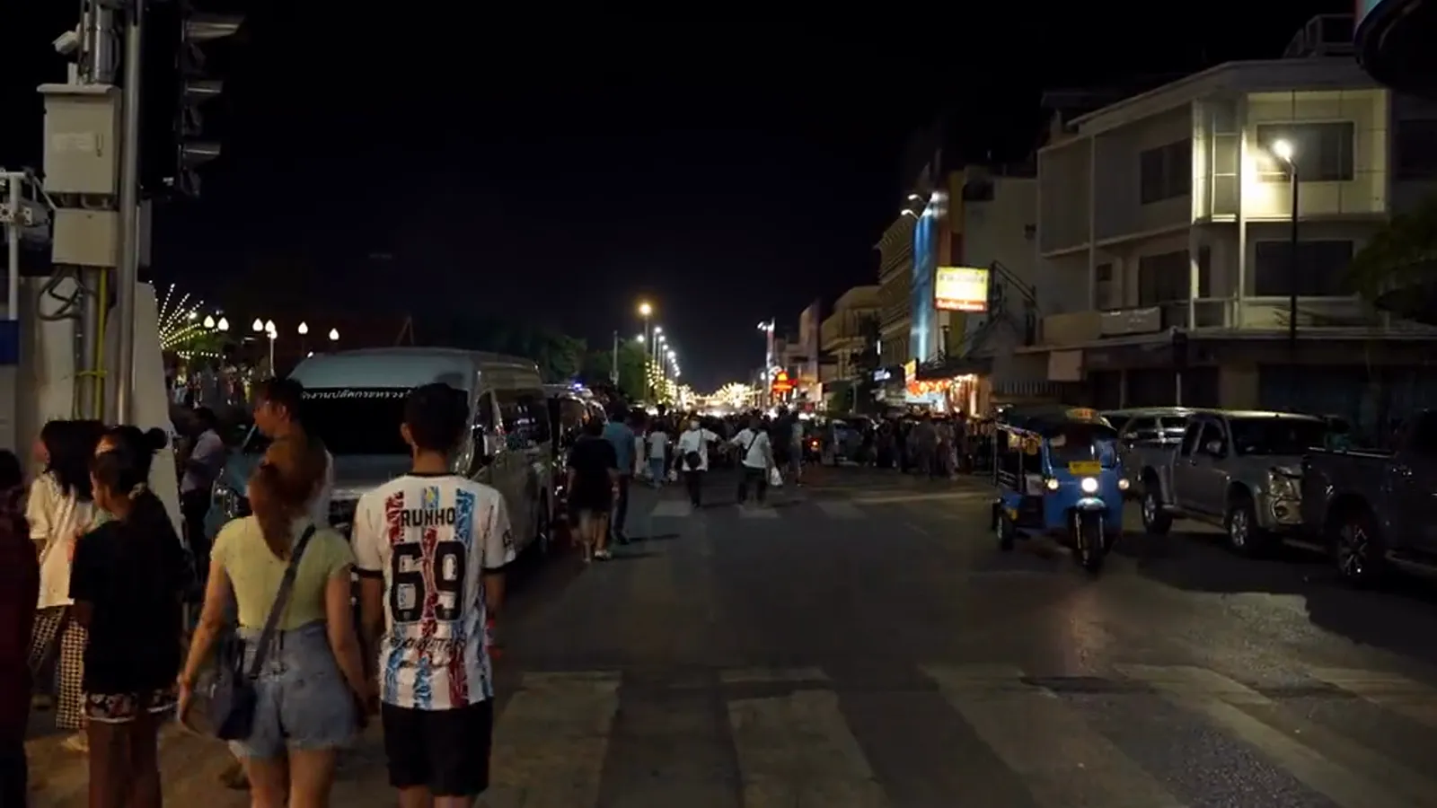 A Southeast Asian city street glowing at night