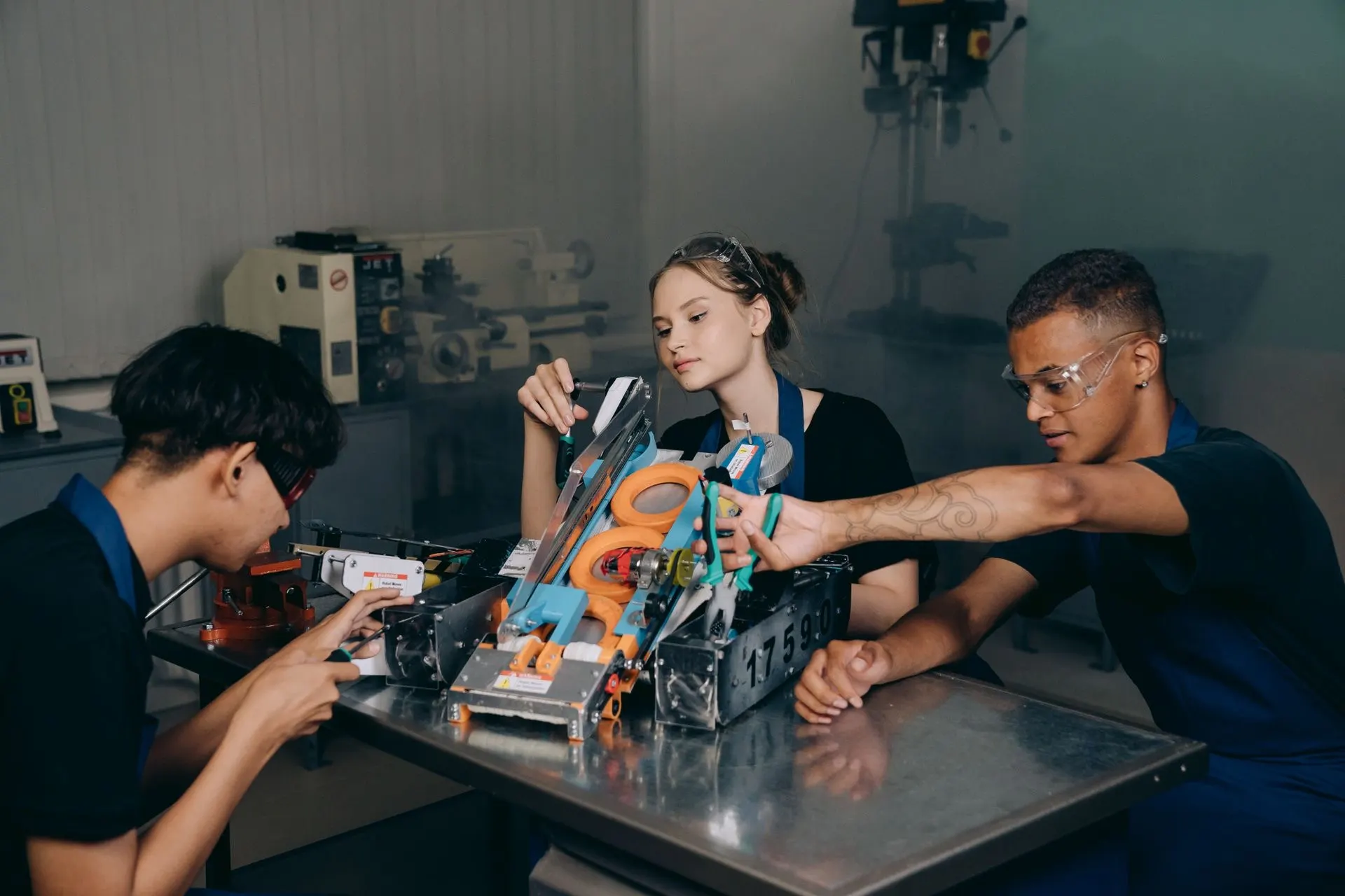 Teens working on competition robots under dramatic light